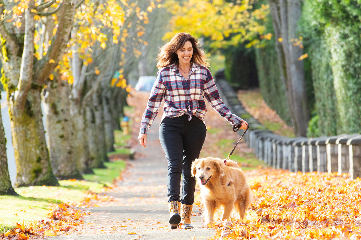 Women walking dog in the fall